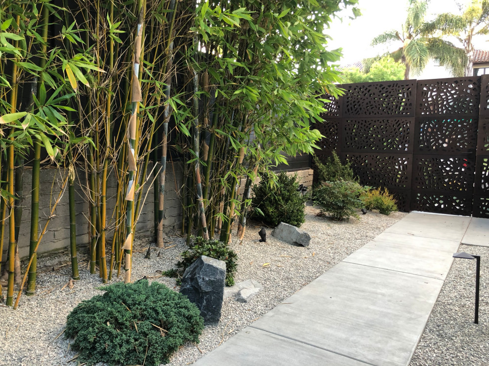 Esempio di un giardino xeriscape minimalista esposto in pieno sole di medie dimensioni e davanti casa con sassi e rocce e ghiaia