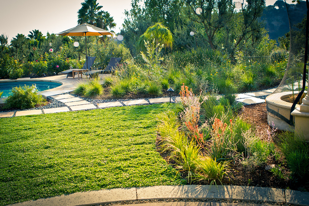 This is an example of a large traditional drought-tolerant backyard concrete paver garden path in Los Angeles.