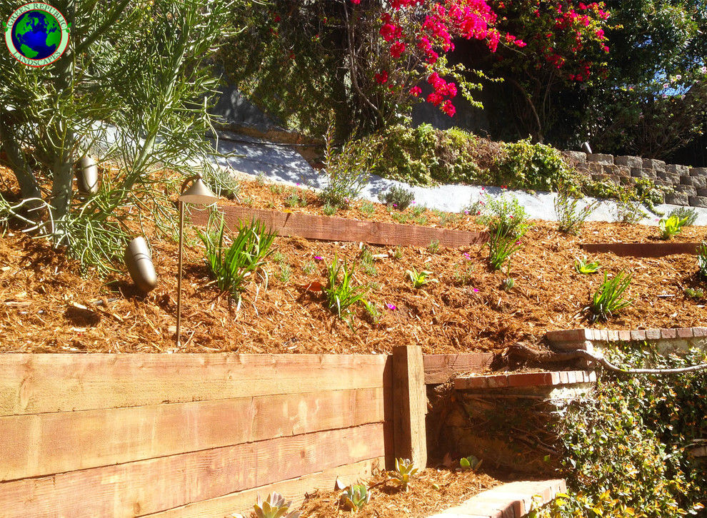 Medelhavsstil inredning av en mellanstor trädgård i delvis sol som tål torka och i slänt, med en trädgårdsgång och marksten i tegel