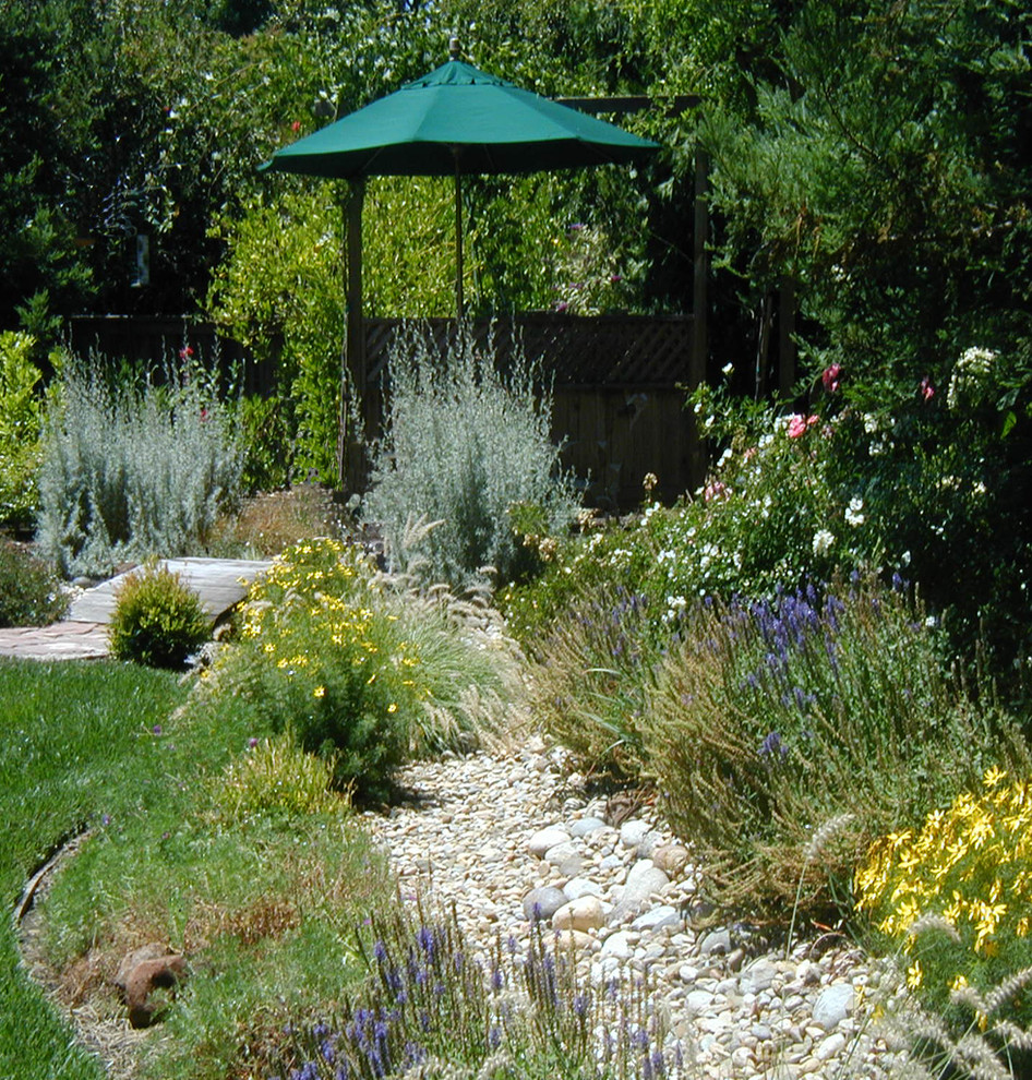 Foto de jardín de secano de estilo de casa de campo de tamaño medio en patio trasero con exposición total al sol y gravilla