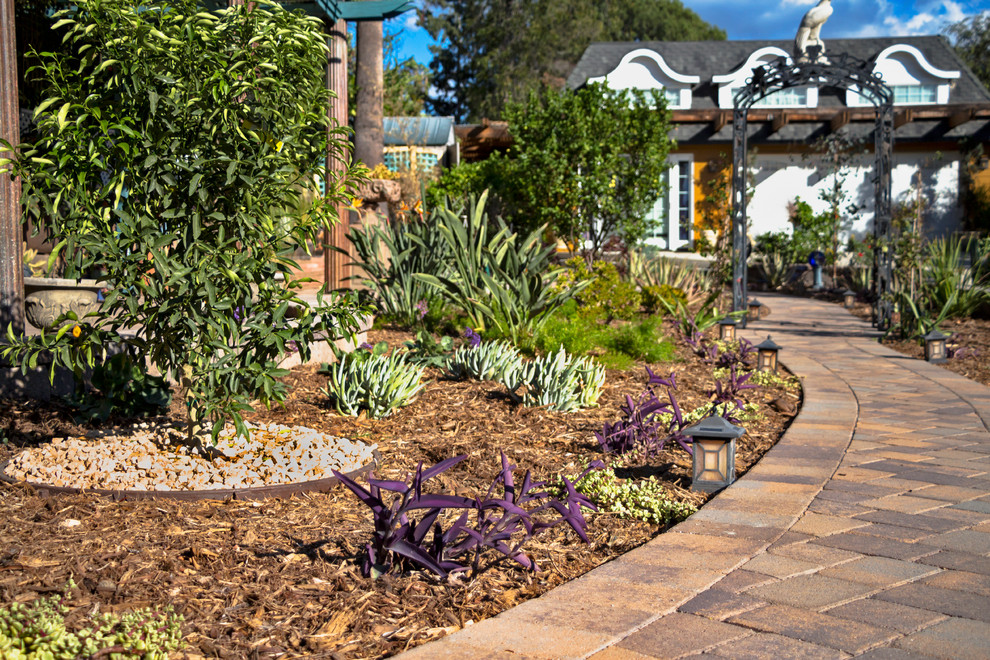 Esempio di un giardino formale american style esposto in pieno sole dietro casa con un ingresso o sentiero e pavimentazioni in mattoni