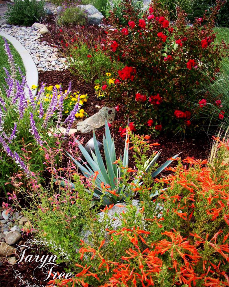 Photo of a mid-sized traditional drought-tolerant and full sun front yard river rock flower bed in Los Angeles.