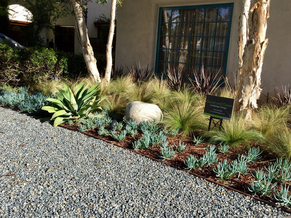 This is an example of a mid-sized mediterranean drought-tolerant and full sun front yard brick landscaping in Los Angeles.