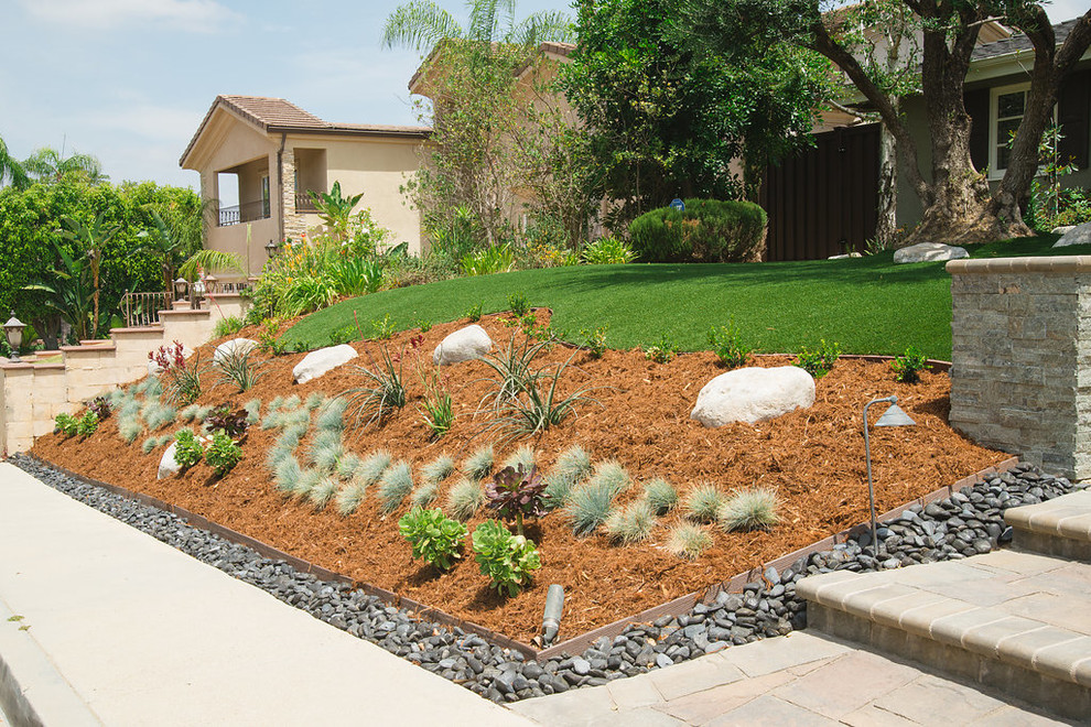This is an example of a mid-sized drought-tolerant and full sun front yard mulch landscaping in Los Angeles for spring.