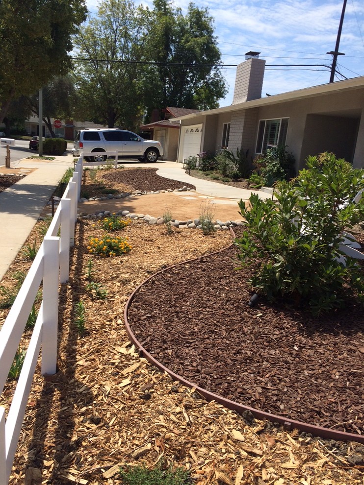 This is an example of a mid-sized coastal full sun front yard mulch landscaping in Los Angeles.