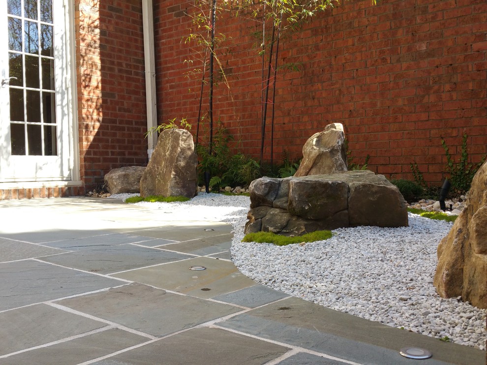 На фото: маленький тенистый регулярный сад на заднем дворе в восточном стиле с садовой дорожкой или калиткой и покрытием из каменной брусчатки для на участке и в саду с