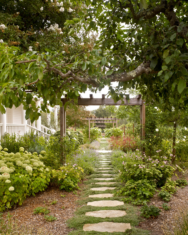 Idée de décoration pour un aménagement d'entrée ou allée de jardin champêtre avec une exposition partiellement ombragée et des pavés en pierre naturelle.