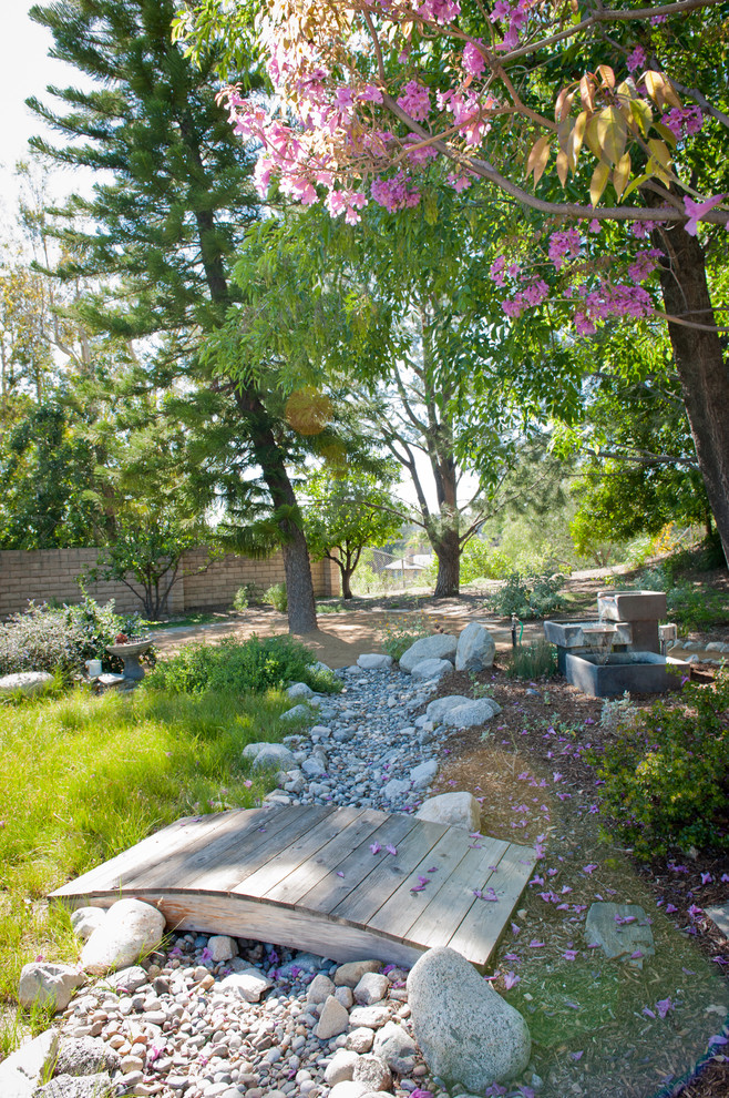 Cette photo montre un grand jardin arrière montagne au printemps avec une exposition partiellement ombragée et une terrasse en bois.