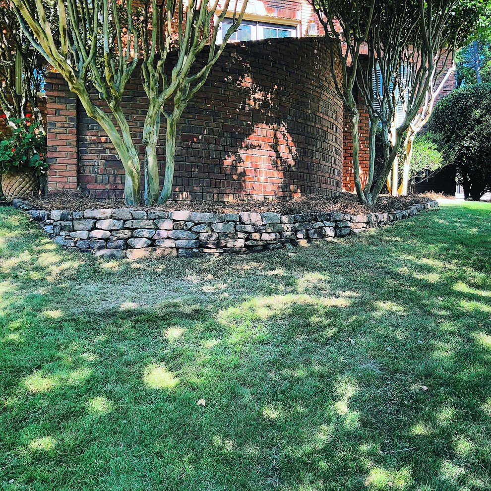 Diseño de jardín clásico en patio delantero con roca decorativa y piedra decorativa