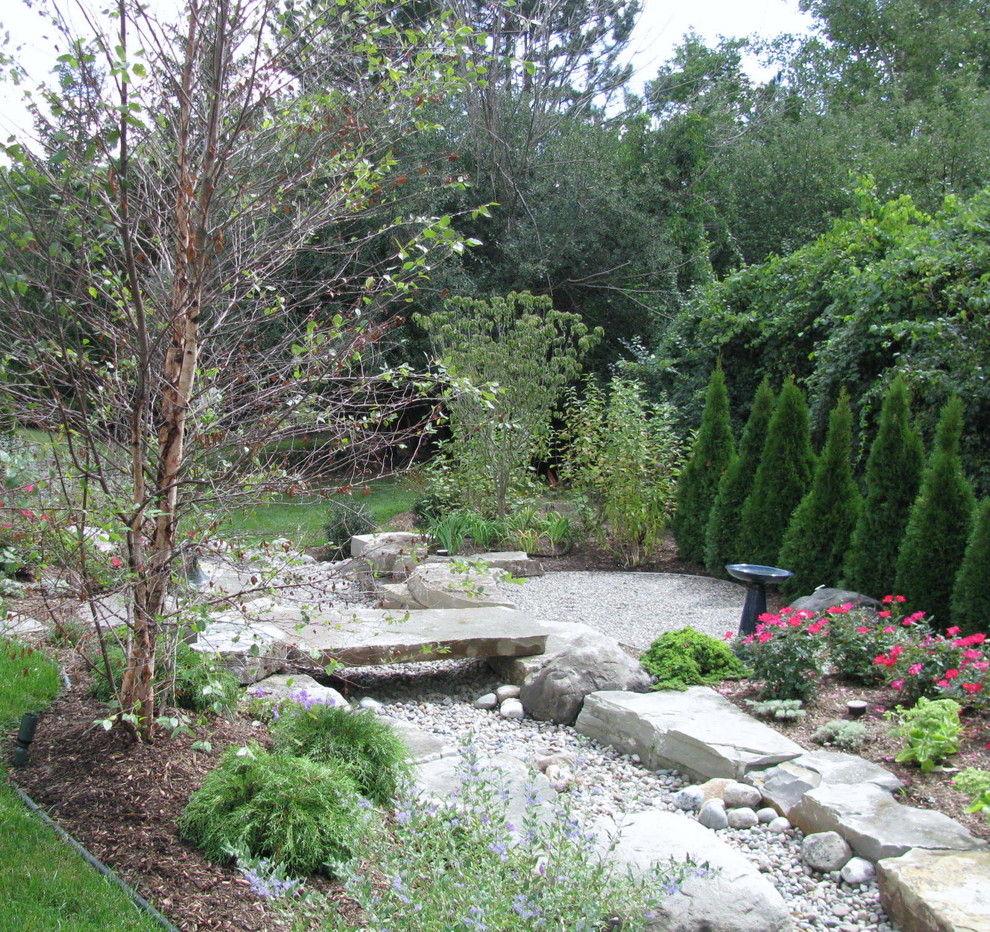 Idee per un piccolo giardino xeriscape rustico esposto in pieno sole dietro casa in estate con pavimentazioni in pietra naturale e un muro di contenimento
