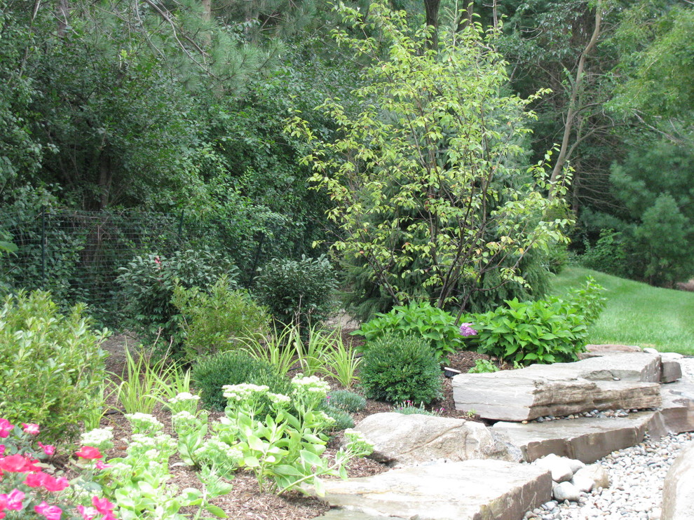 Ispirazione per un piccolo giardino xeriscape stile rurale esposto in pieno sole dietro casa in estate con pavimentazioni in pietra naturale e un muro di contenimento
