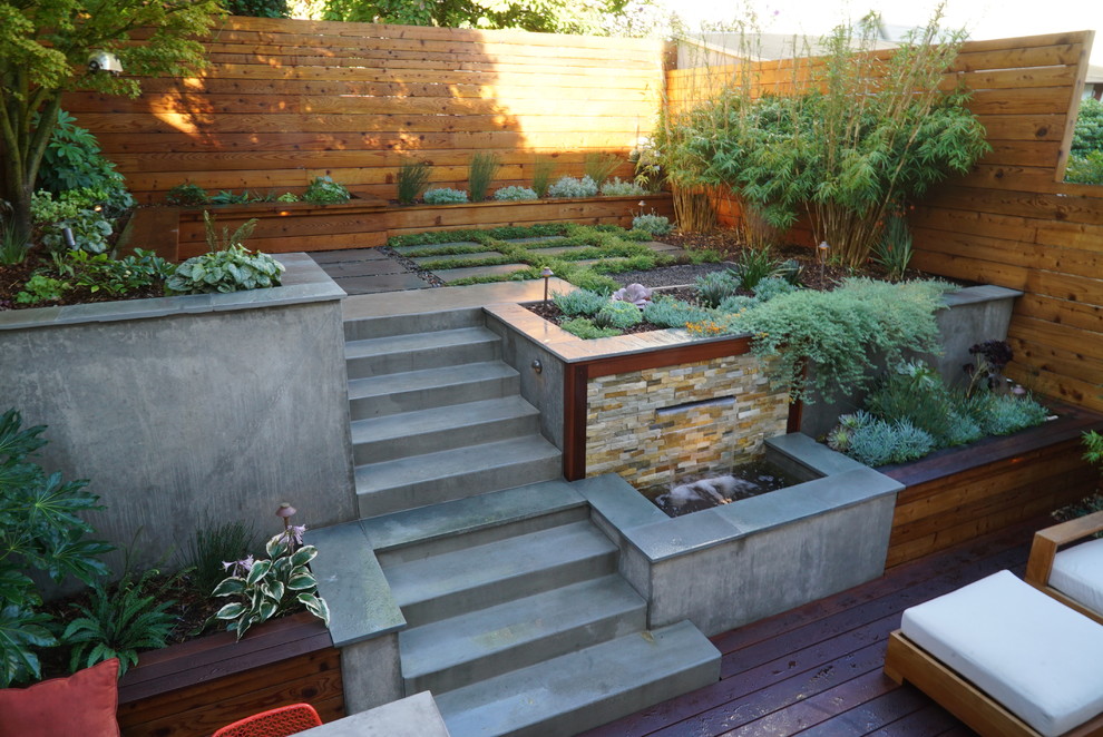 Photo of a mid-sized contemporary partial sun backyard retaining wall landscape in San Francisco with decking.
