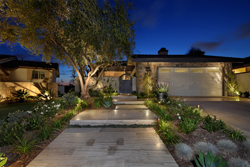 Diseño de jardín actual de tamaño medio en patio delantero con exposición total al sol y adoquines de piedra natural