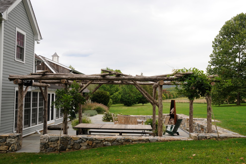 Foto di un grande giardino formale country esposto a mezz'ombra dietro casa in estate con pavimentazioni in pietra naturale