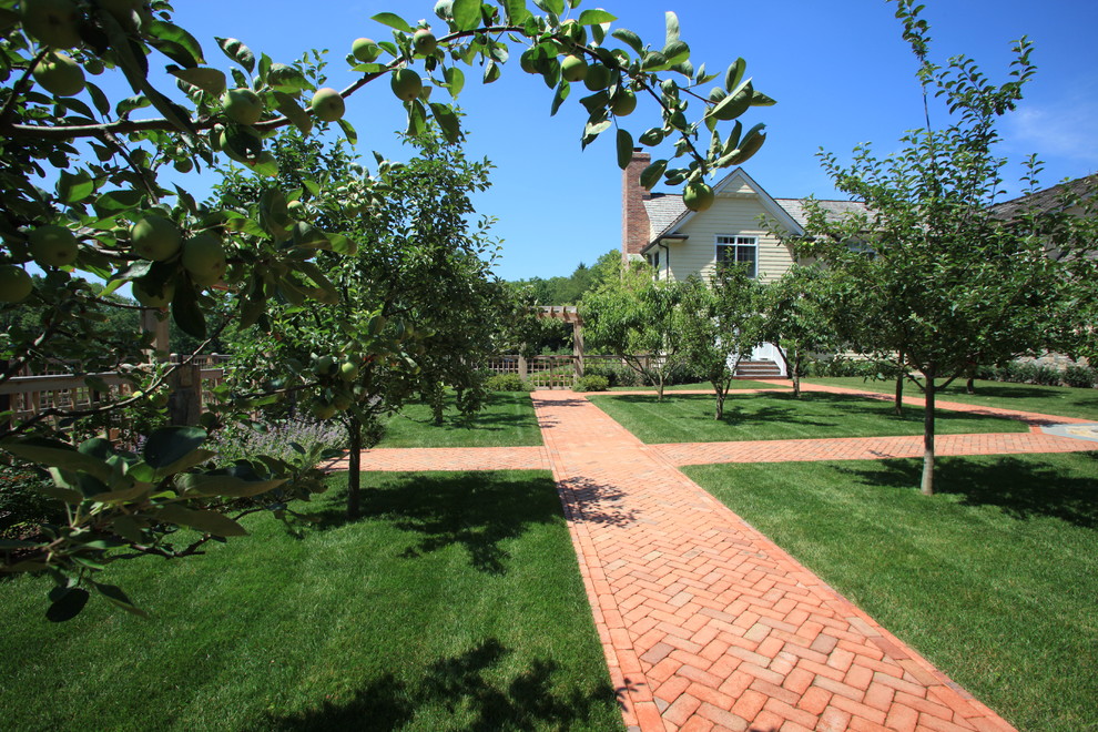 Inspiration for a large traditional full sun backyard brick formal garden in New York.