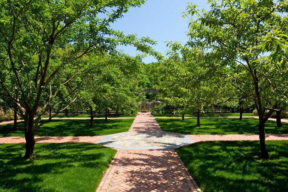 Esempio di un grande giardino formale classico esposto in pieno sole dietro casa in estate con un ingresso o sentiero e pavimentazioni in mattoni
