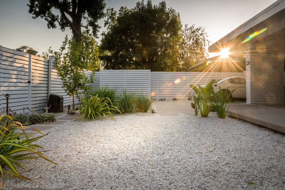 Imagen de jardín de secano retro de tamaño medio en patio trasero con exposición parcial al sol y gravilla