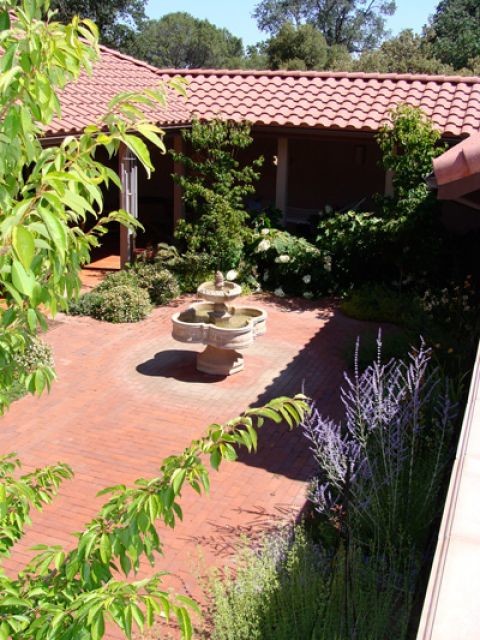 Design ideas for a mid-sized traditional partial sun courtyard brick water fountain landscape in Other.