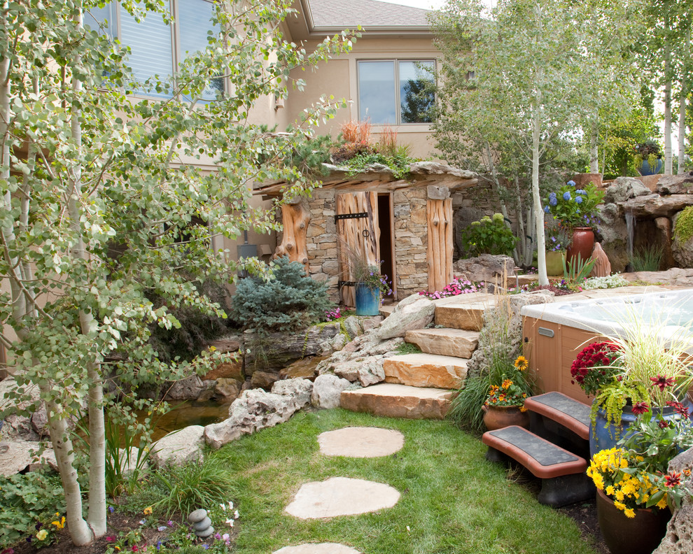 Design ideas for a large traditional backyard stone landscaping in Denver.