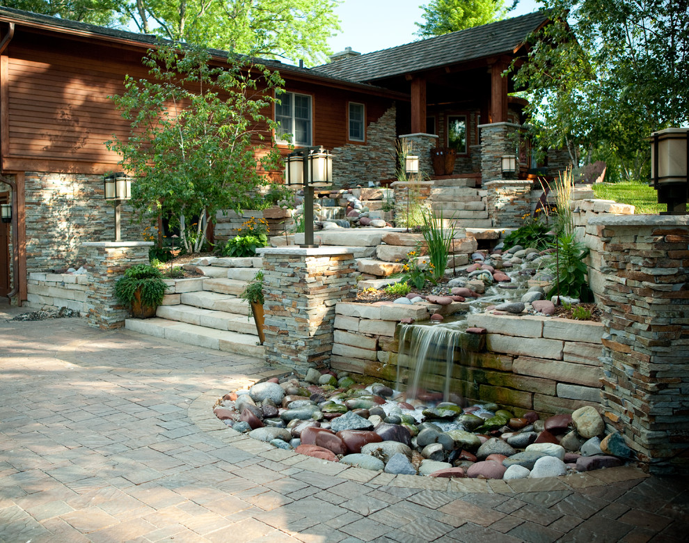 Cette photo montre un grand jardin arrière tendance avec un point d'eau, une exposition ensoleillée et des pavés en pierre naturelle.