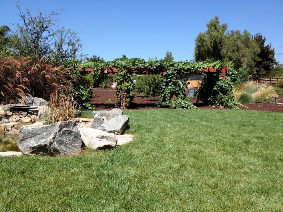 This is an example of a large traditional full sun backyard mulch landscaping in San Diego.