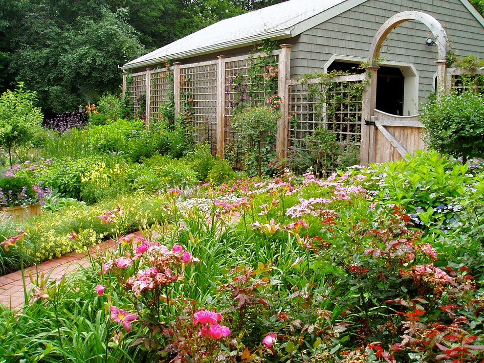 Foto de jardín tradicional de tamaño medio en patio trasero con exposición parcial al sol y adoquines de ladrillo