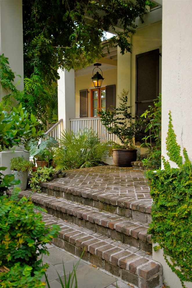 Design ideas for a world-inspired front garden in Charleston with a potted garden and brick paving.