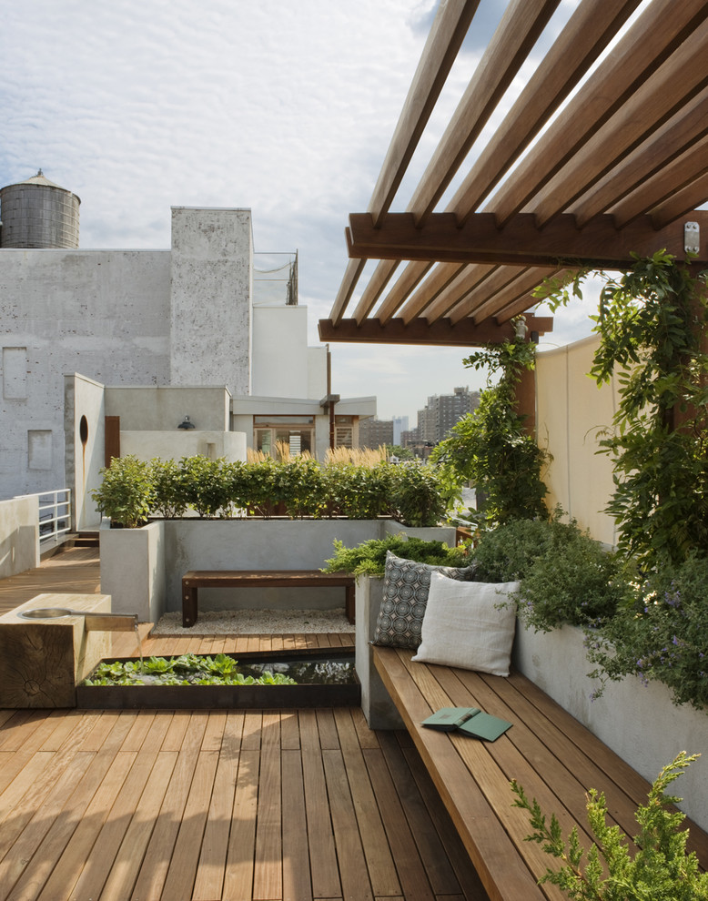 This is an example of a large traditional full sun rooftop water fountain landscape in New York with decking.