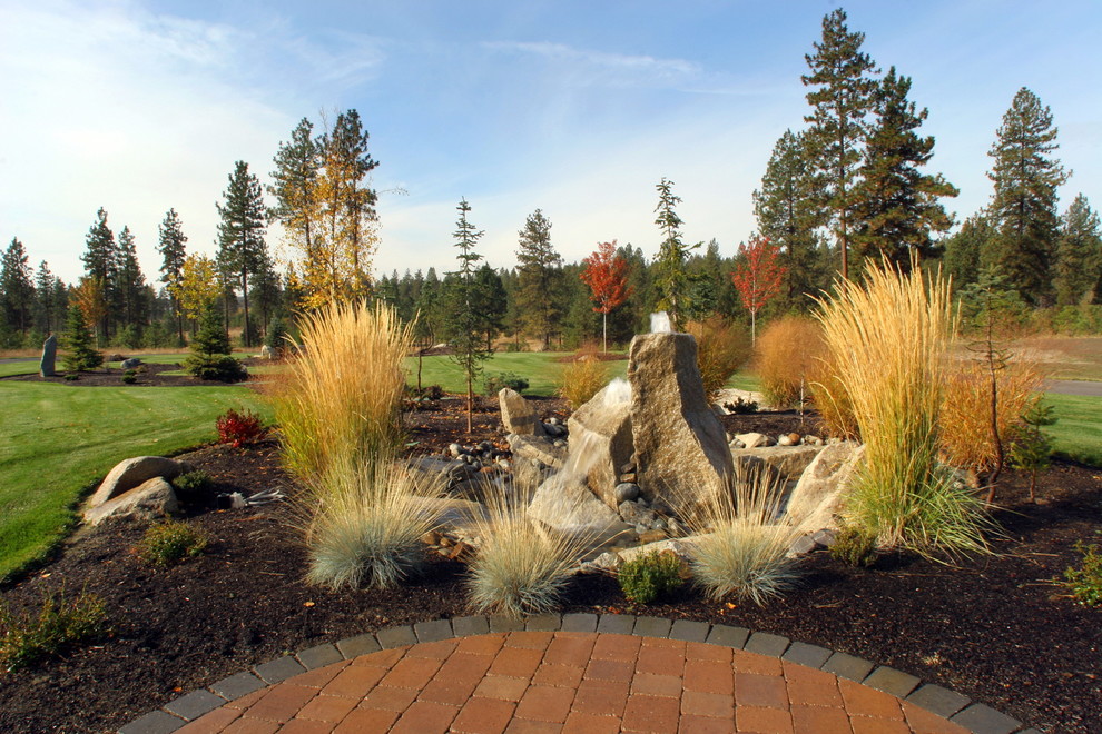 Immagine di un grande giardino xeriscape eclettico dietro casa con fontane e pavimentazioni in pietra naturale