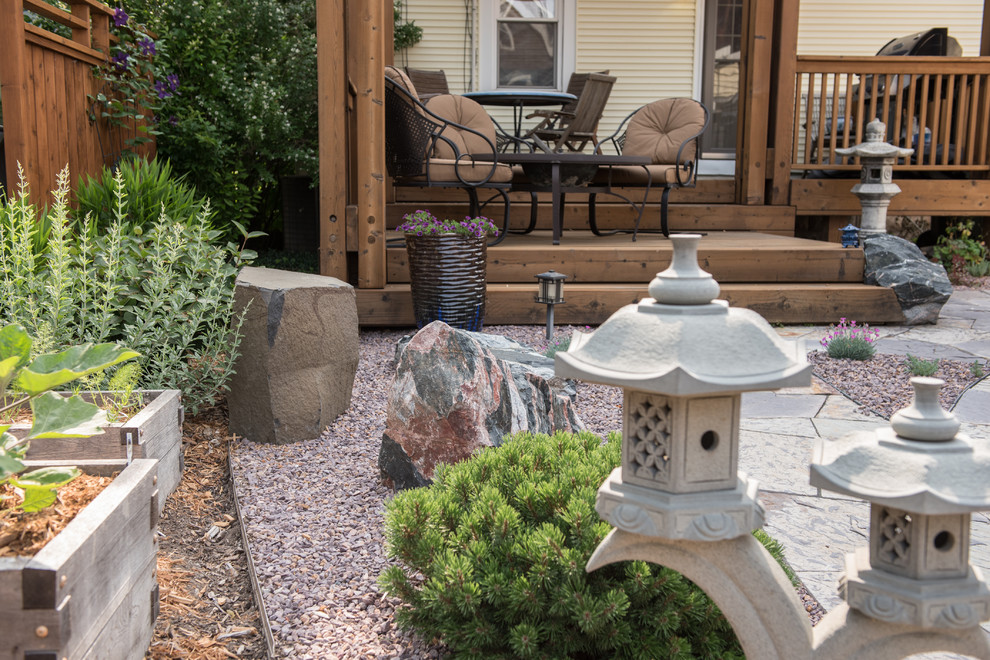 This is an example of a medium sized world-inspired back formal full sun garden for summer in Milwaukee with a garden path and gravel.