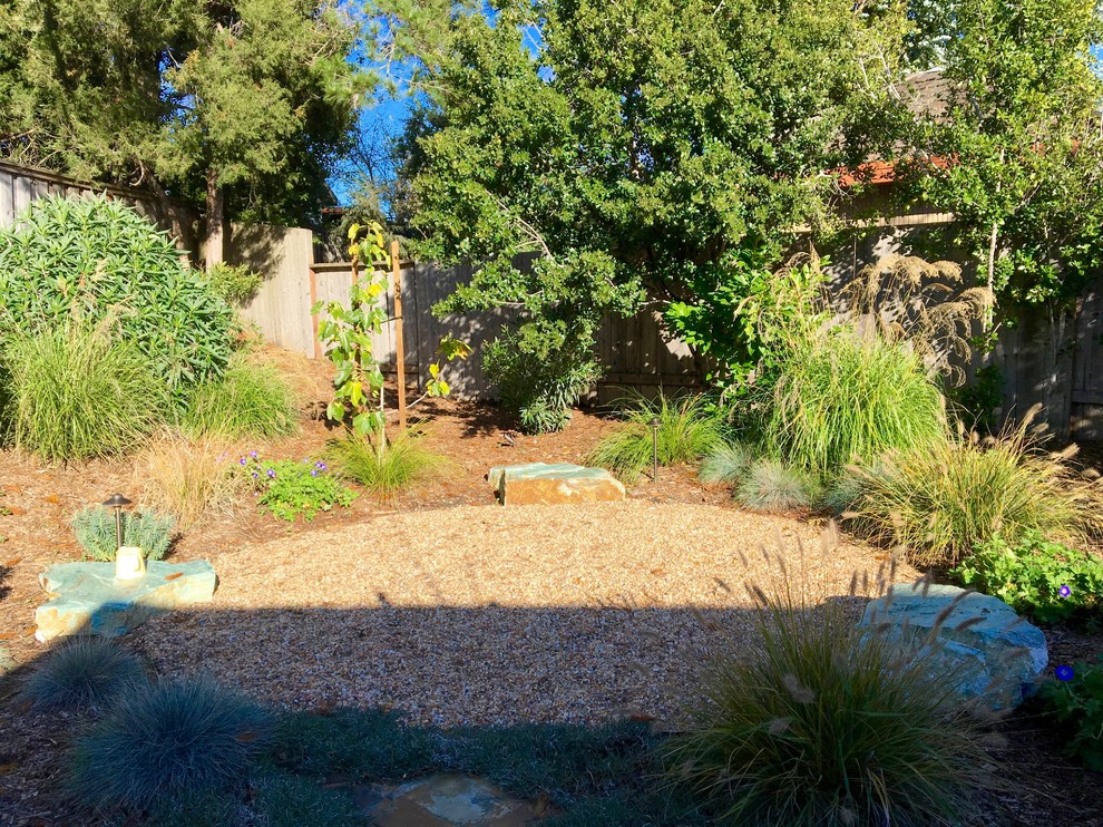 Ejemplo de jardín de secano ecléctico en patio trasero con brasero y adoquines de piedra natural