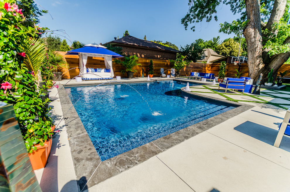 Foto de piscina clásica de tamaño medio en patio trasero con adoquines de hormigón