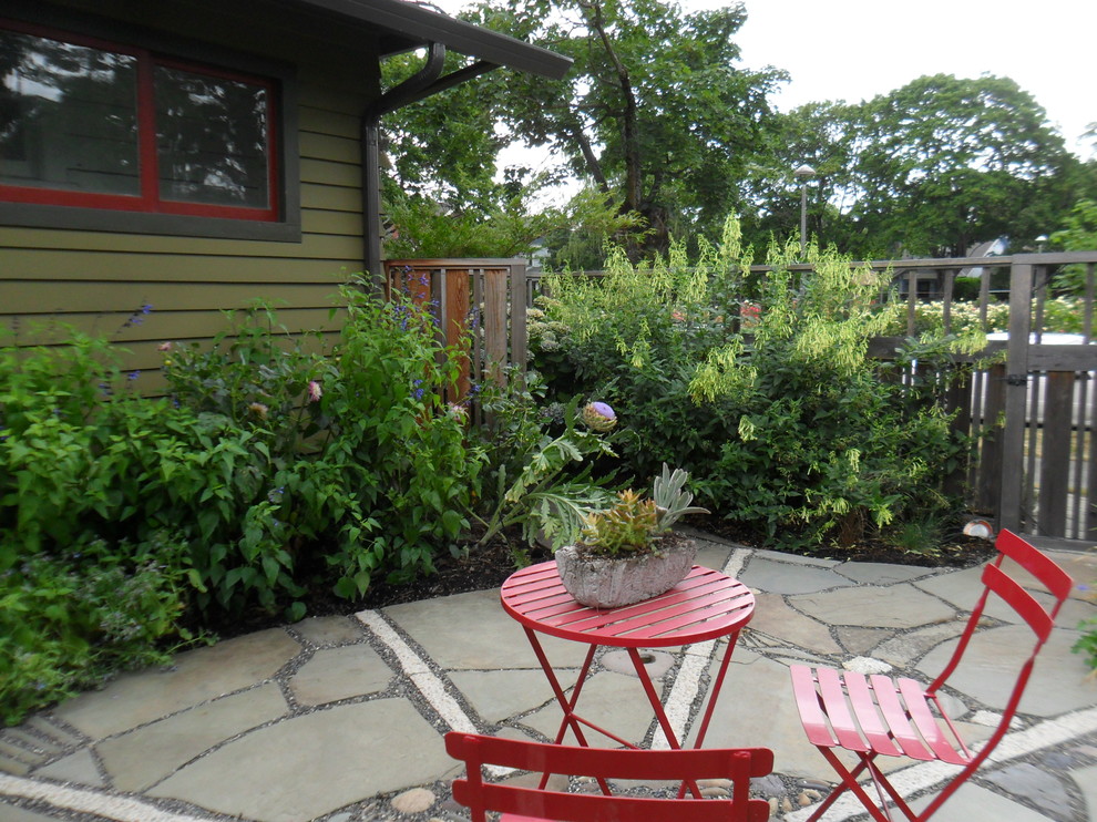 Aménagement d'un petit jardin arrière éclectique l'été avec une exposition ensoleillée et des pavés en pierre naturelle.
