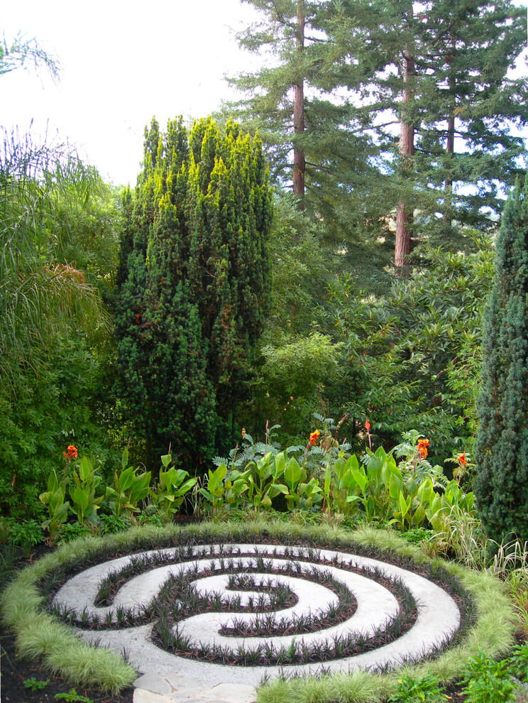 Diseño de jardín bohemio en patio trasero con gravilla