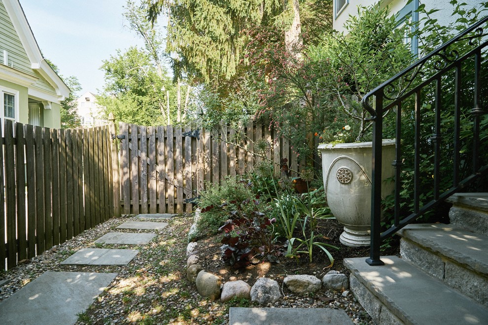 На фото: большой осенний регулярный сад на переднем дворе в классическом стиле с садовой дорожкой или калиткой, полуденной тенью и покрытием из каменной брусчатки
