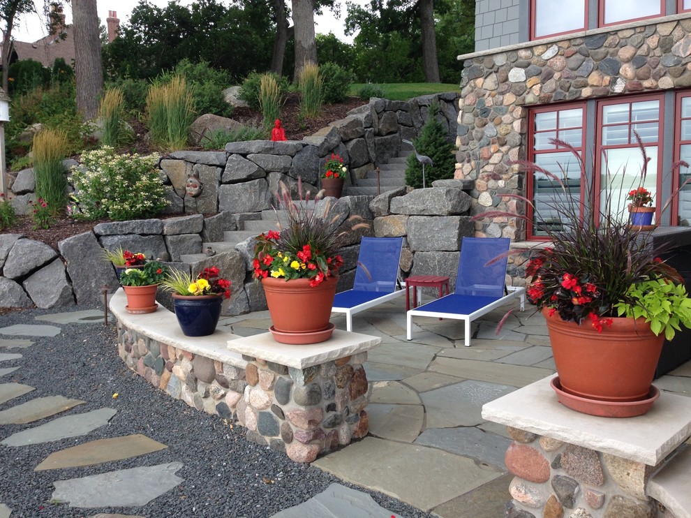 Diseño de jardín costero de tamaño medio en patio trasero con exposición total al sol y adoquines de piedra natural