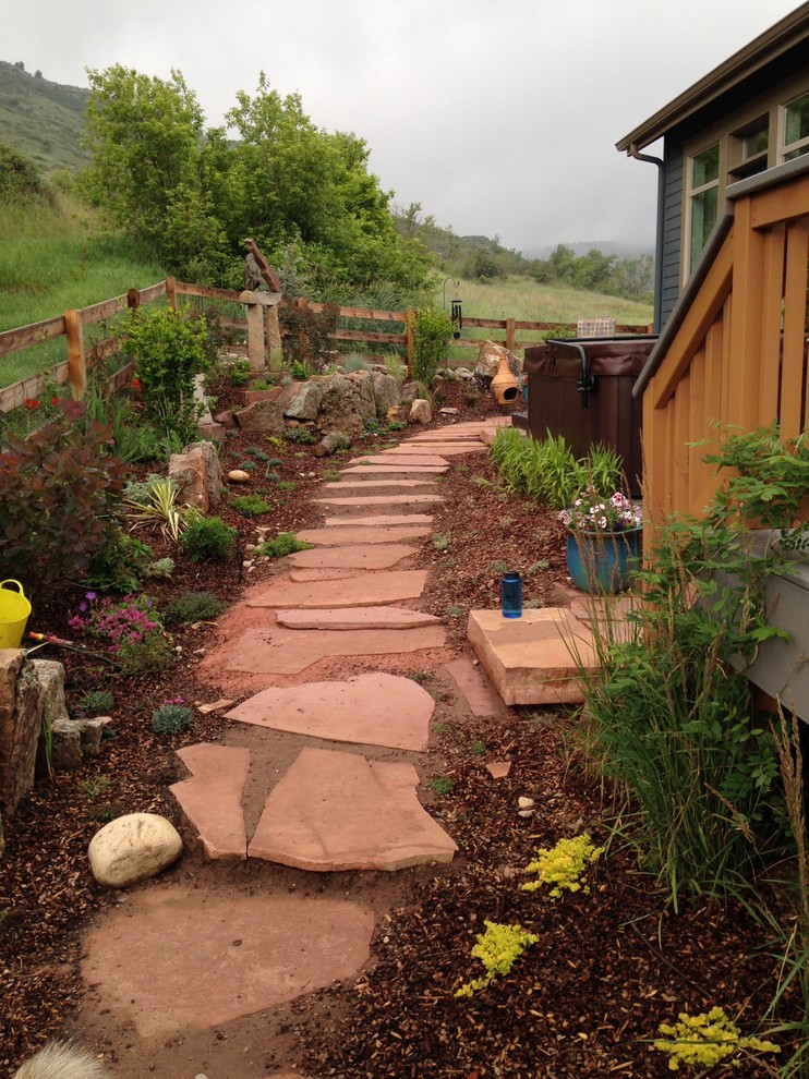 Inspiration for a large bohemian side xeriscape full sun garden in Denver with a garden path and natural stone paving.