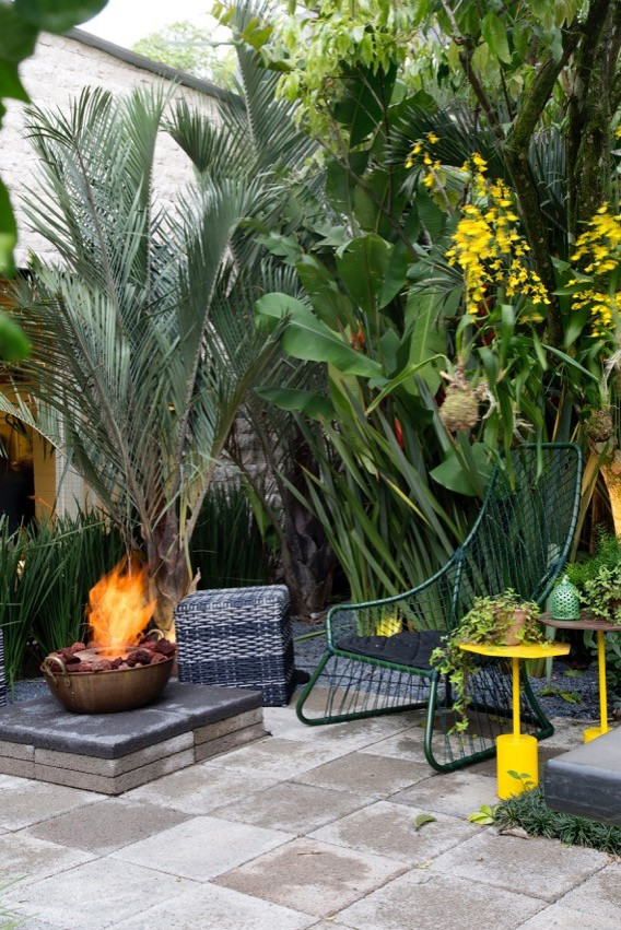 Foto di un grande giardino formale tropicale esposto a mezz'ombra nel cortile laterale con un caminetto e pavimentazioni in pietra naturale