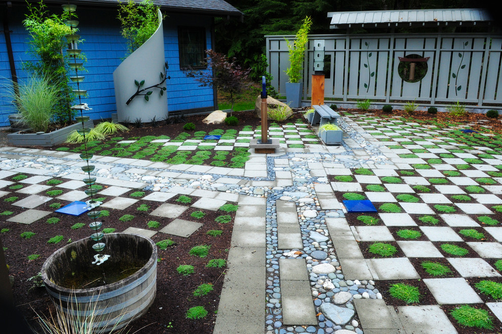 Bild på en mellanstor eklektisk trädgård framför huset, med en trädgårdsgång och marksten i betong