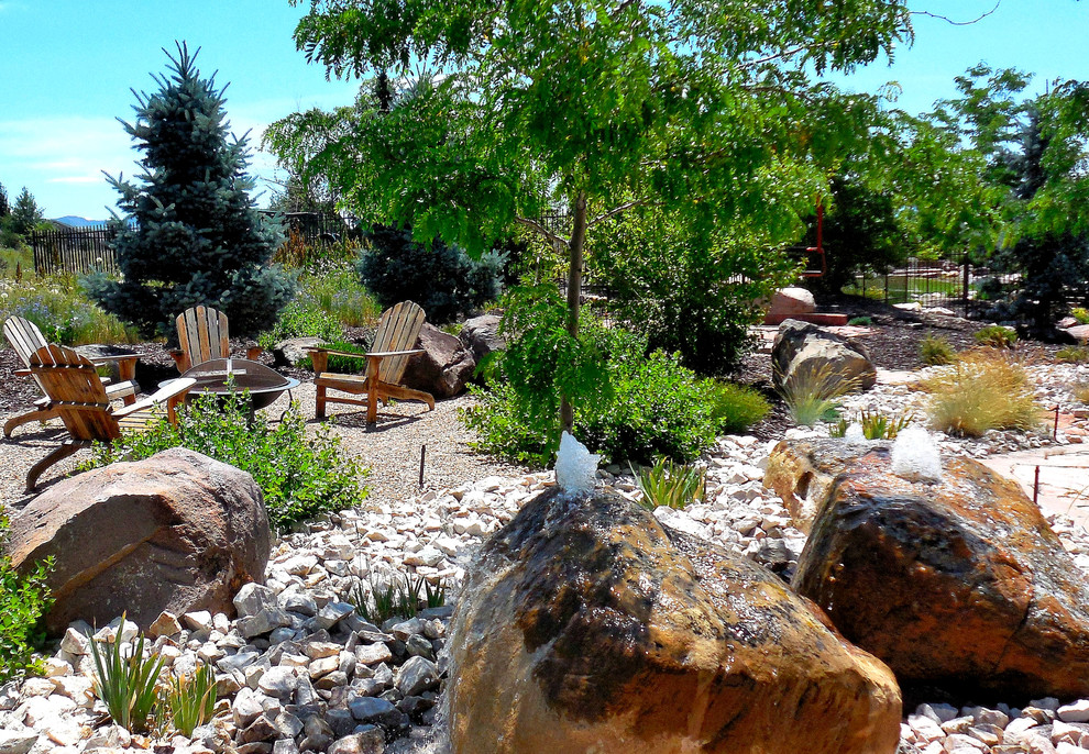 Medium sized traditional back xeriscape full sun garden for summer in Salt Lake City with a water feature and gravel.