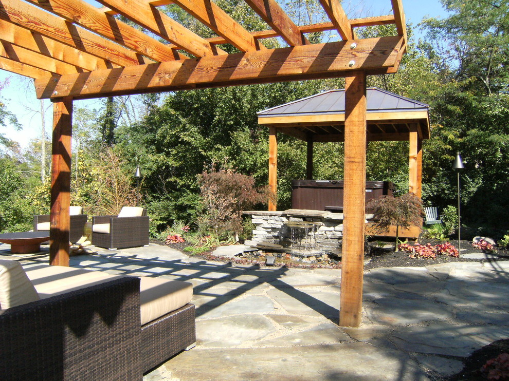 Foto de patio bohemio de tamaño medio en patio trasero con fuente y adoquines de piedra natural