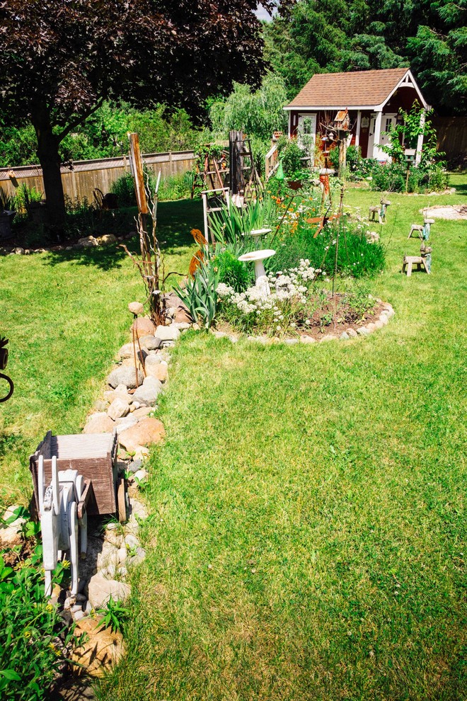 Cette photo montre un grand jardin arrière romantique l'été avec une exposition ensoleillée.
