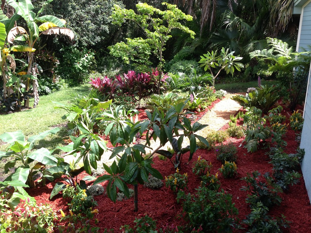 Inspiration for a mid-sized tropical partial sun backyard gravel landscaping in Miami.