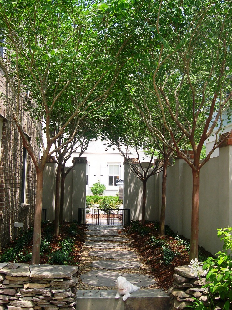 Small contemporary courtyard garden for summer in Charleston with a garden path and natural stone paving.