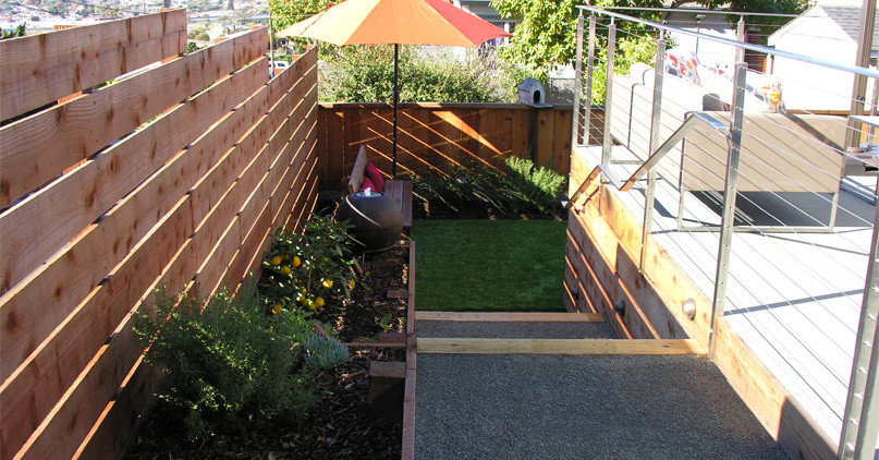 Modelo de jardín retro extra grande en verano en patio trasero con muro de contención, exposición total al sol y gravilla