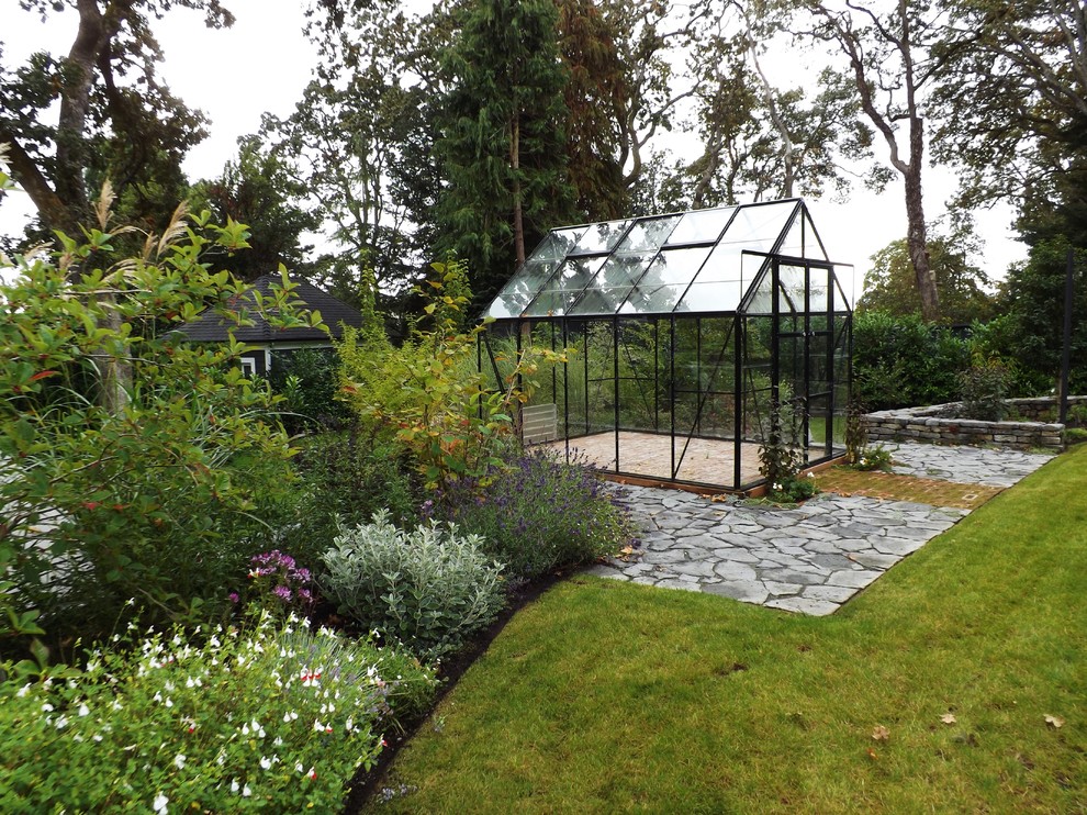 Idee per un ampio giardino classico esposto in pieno sole dietro casa con un muro di contenimento e pavimentazioni in pietra naturale