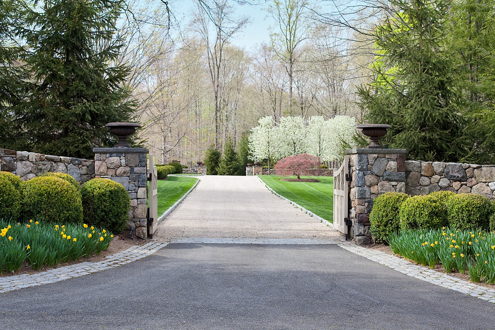 Photo of a large classic front driveway full sun garden for spring in New York with gravel and a garden path.