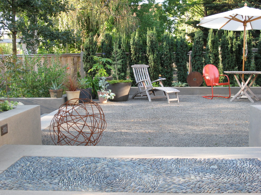 This is an example of a mid-sized eclectic courtyard gravel landscaping in Portland.