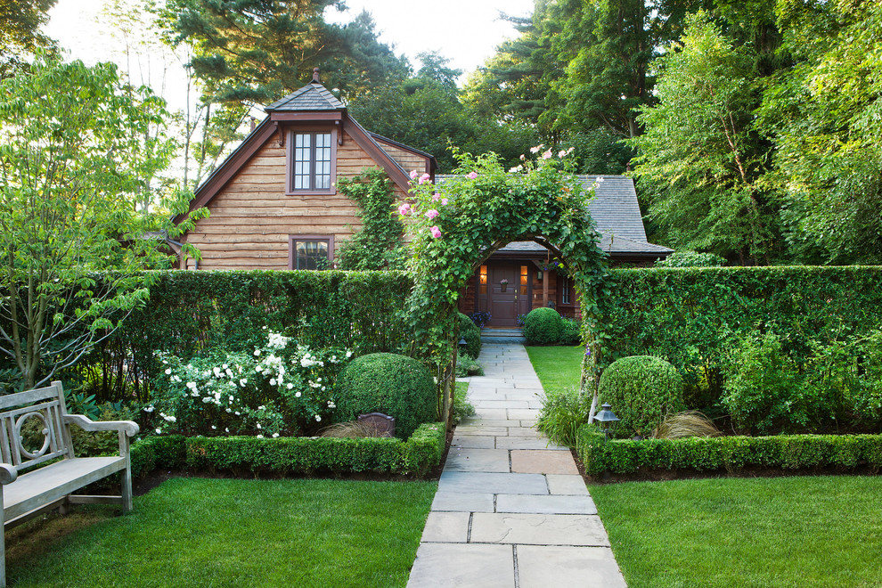 Пример оригинального дизайна: регулярный сад на переднем дворе в классическом стиле с садовой дорожкой или калиткой
