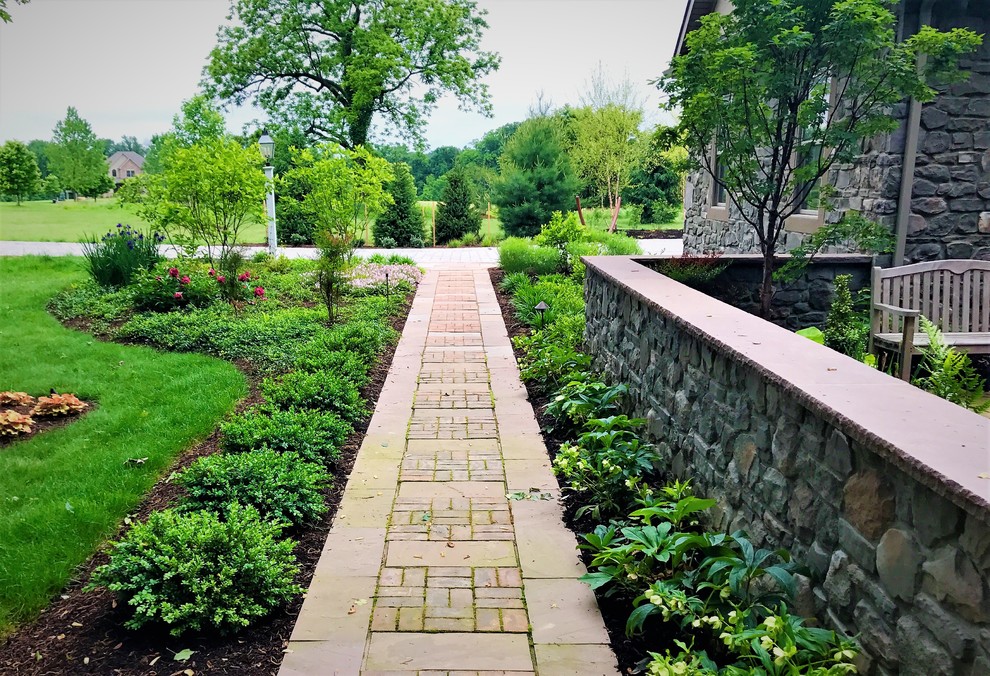 Großer Klassischer Vorgarten mit Natursteinplatten in Sonstige